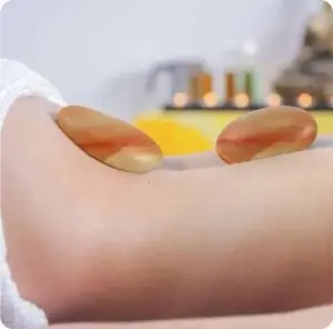 Two himalayan massage stones on the back of a person
