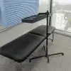 Red light panel mounted on adjustable 360 stand above massage table