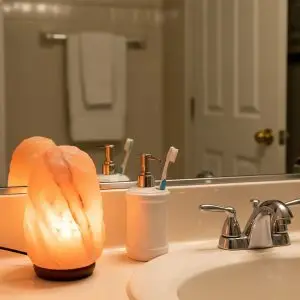 A salt lamp in bathroom adds a warm and inviting glow to an everyday setting.